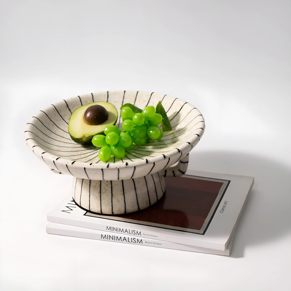 Black and white striped synthetic resin fruit plate on a wooden surface.