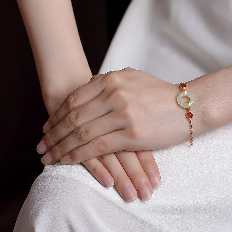 Women's sterling silver bracelet with gold-plated finish and natural Hetian jade peace buckle on adjustable chain