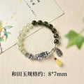 Close-up of a women's silver bracelet with Hetian jade beads and an 8x7mm retro coin charm.