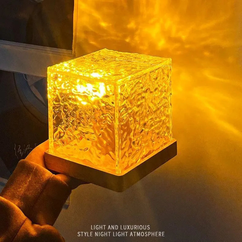 Rotating crystal table lamp projecting blue water ripple light pattern on wall