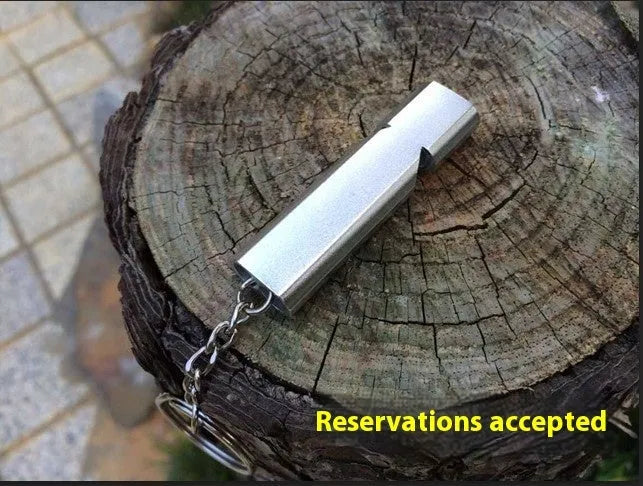 Gold and silver aluminium alloy double-hole survival whistle on a keyring.