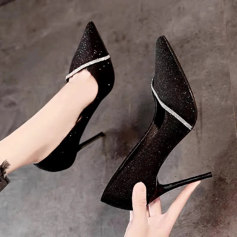 Gold women's stiletto pointed toe high heels on a plain background.