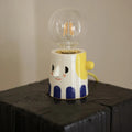 Handmade ceramic table lamp with a spherical white ball headlight shade on a solid base.
