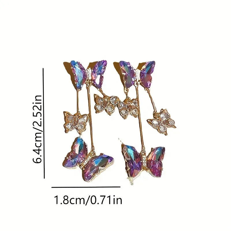 A pair of silver and blue purple butterfly tassel earrings with crystal flowers and droplet pendants.