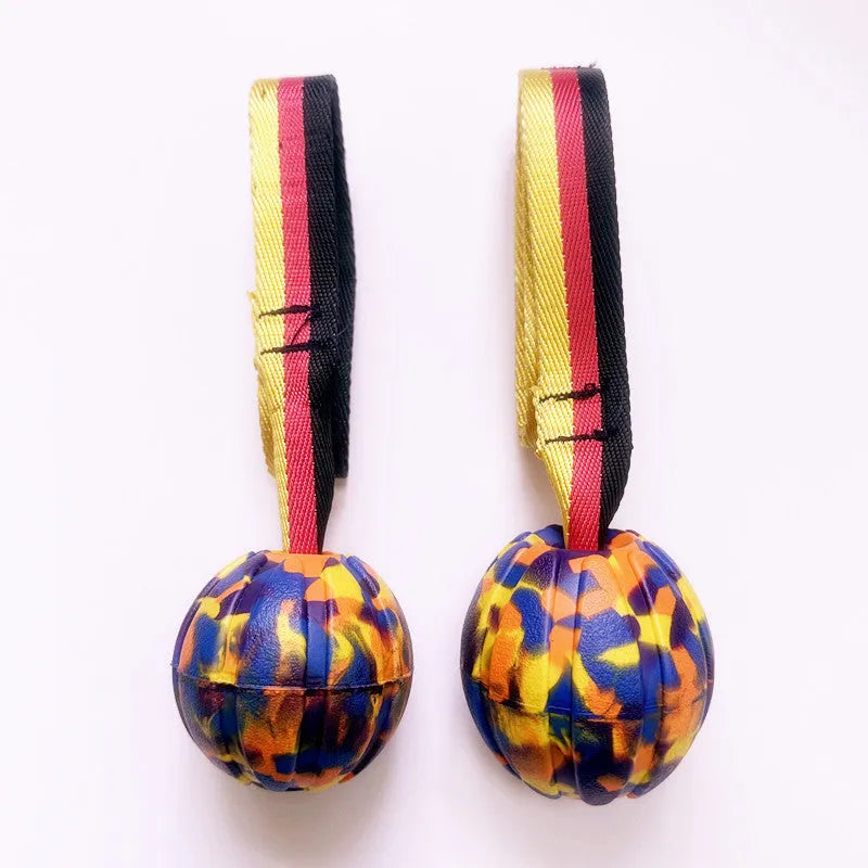 Yellow and camouflage coloured EVA floating dog training balls in different sizes on a blue background.