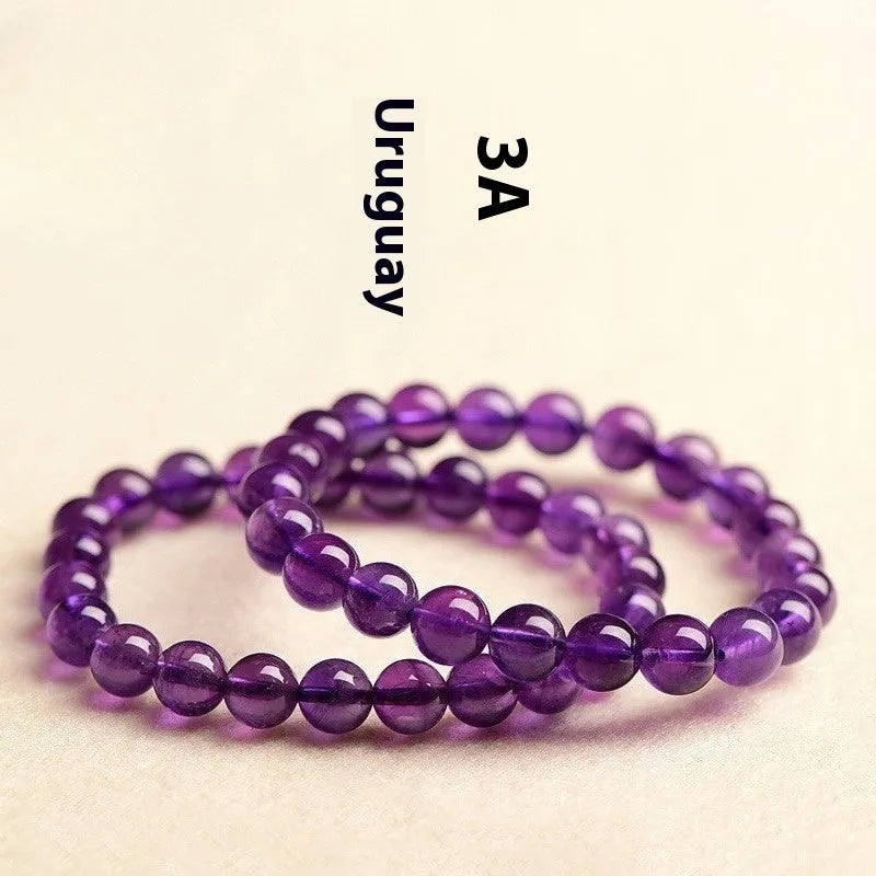 Scattered natural Uruguay amethyst beads for bracelet making in various sizes and purple shades.