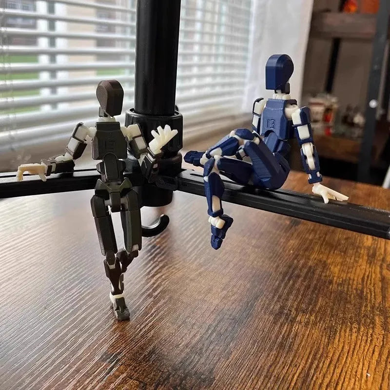Multi-jointed 3D printed robot action model with movable limbs on a desk.