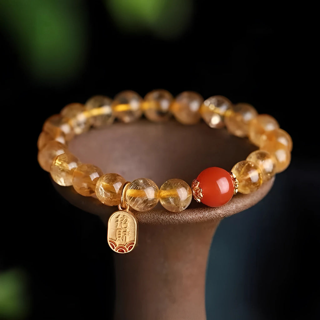 Polished natural red agate bead bracelet on a wrist, showing smooth beads.