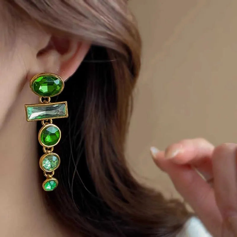 A pair of green gradient geometric drop earrings with inlaid zircon stones and a dangling tassel detail.