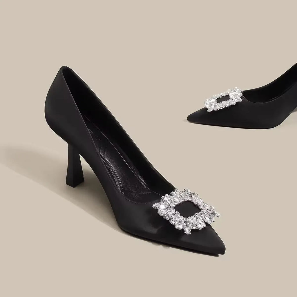 Women's pointed-toe stiletto heels in creamy white or black with a low-cut design and rubber sole.