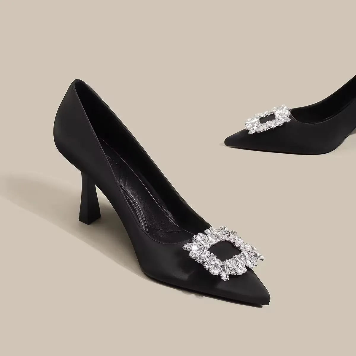 Women's pointed-toe stiletto heels in creamy white or black with a low-cut design and rubber sole.