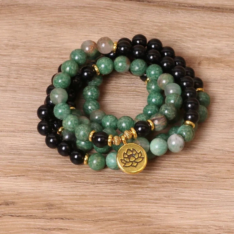 Green and black alloy bead elastic bracelet on a wrist.