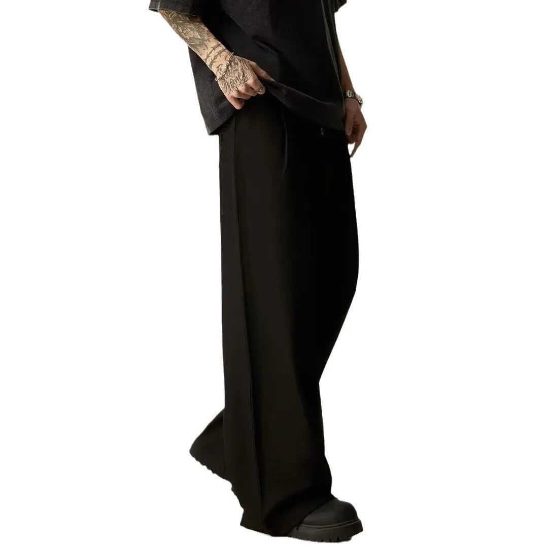 Men's solid colour wide-leg casual trousers in black, showing elastic waist and straight leg cut.