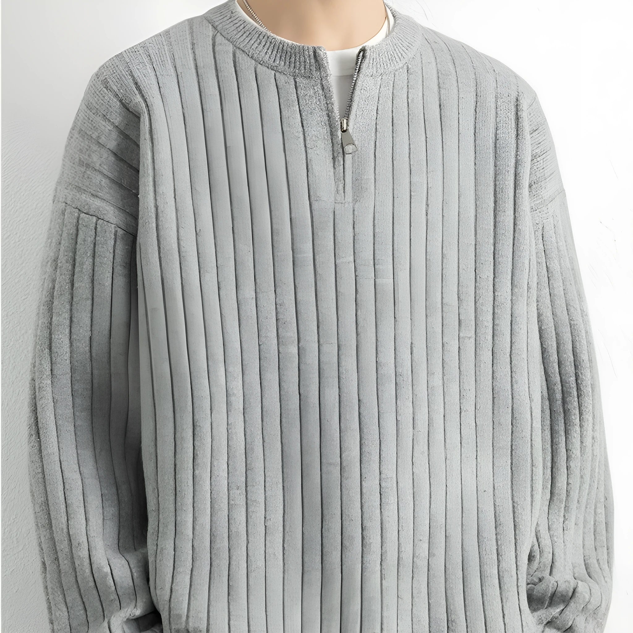 A grey men's half-zip texture knit sweater with a loose fit and long sleeves on a hanger.