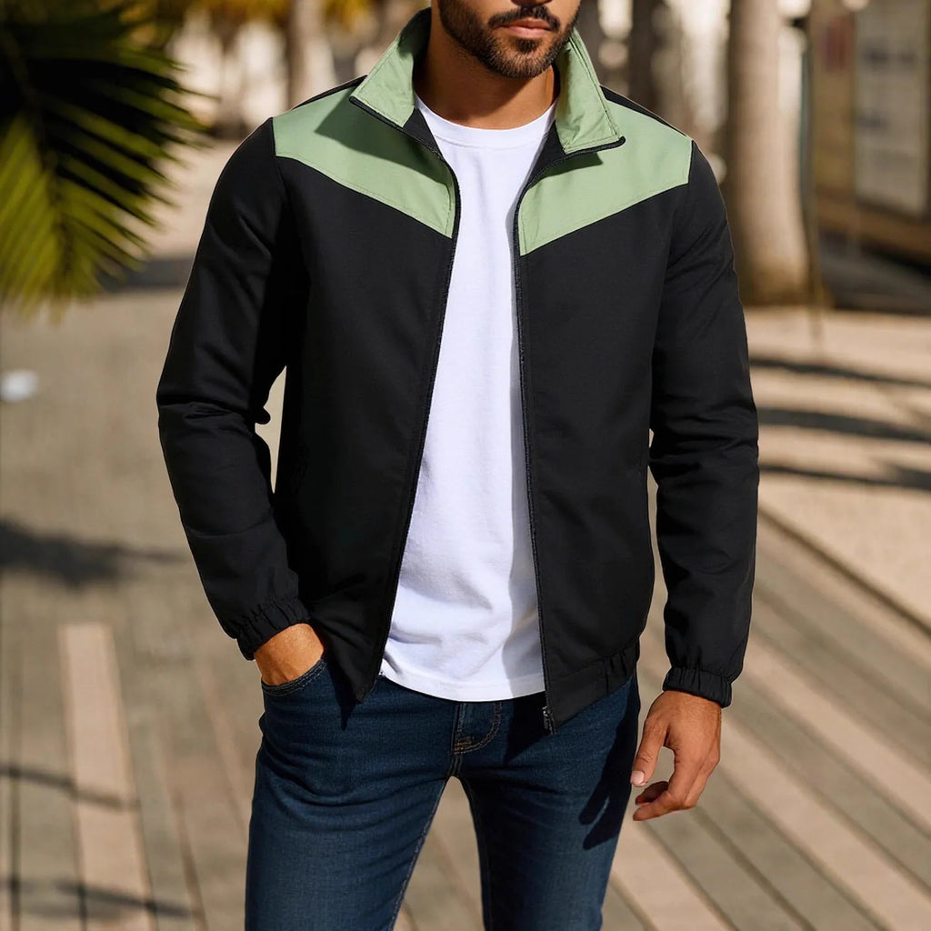 Man wearing a green windproof jacket with a high collar and colour-matched front zipper.