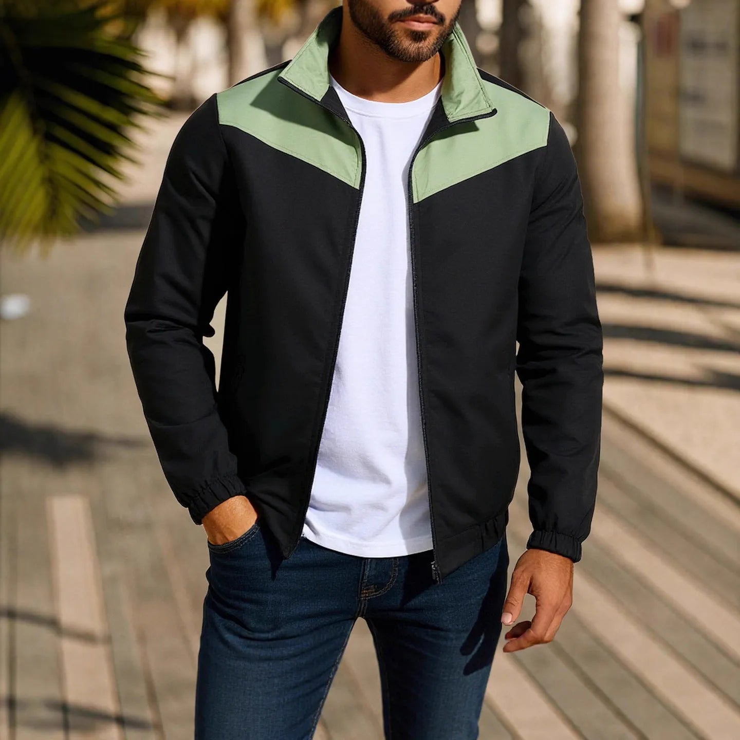 Man wearing a green windproof jacket with a high collar and colour-matched front zipper.