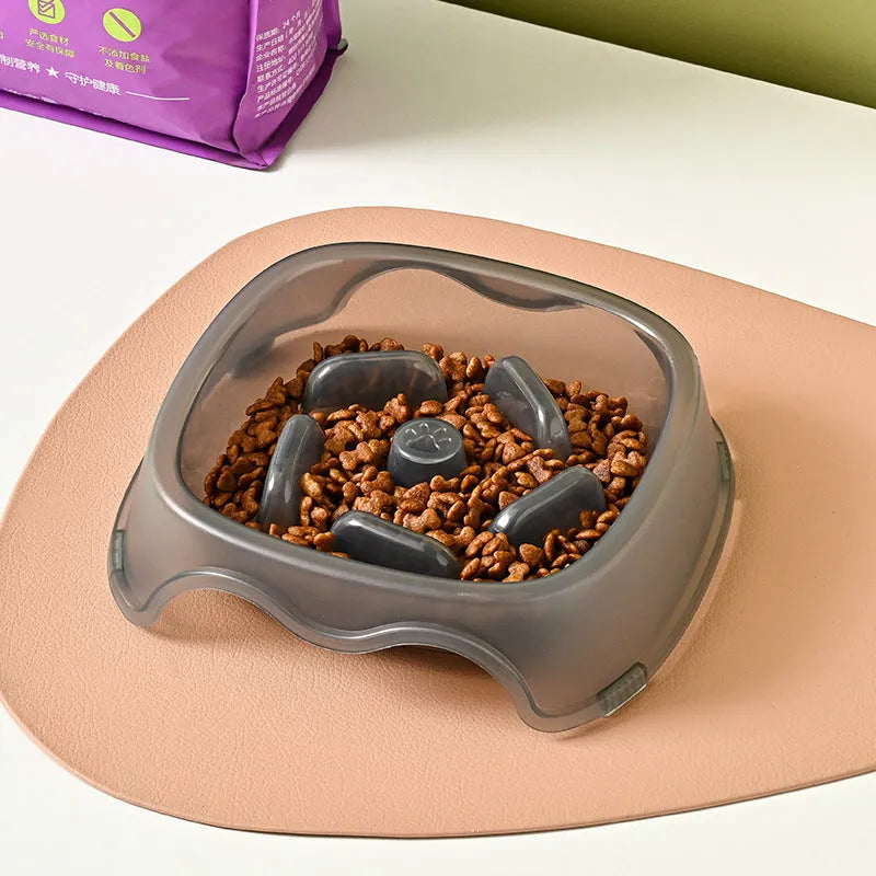A blue plastic slow-feeder dog bowl on a wooden floor.