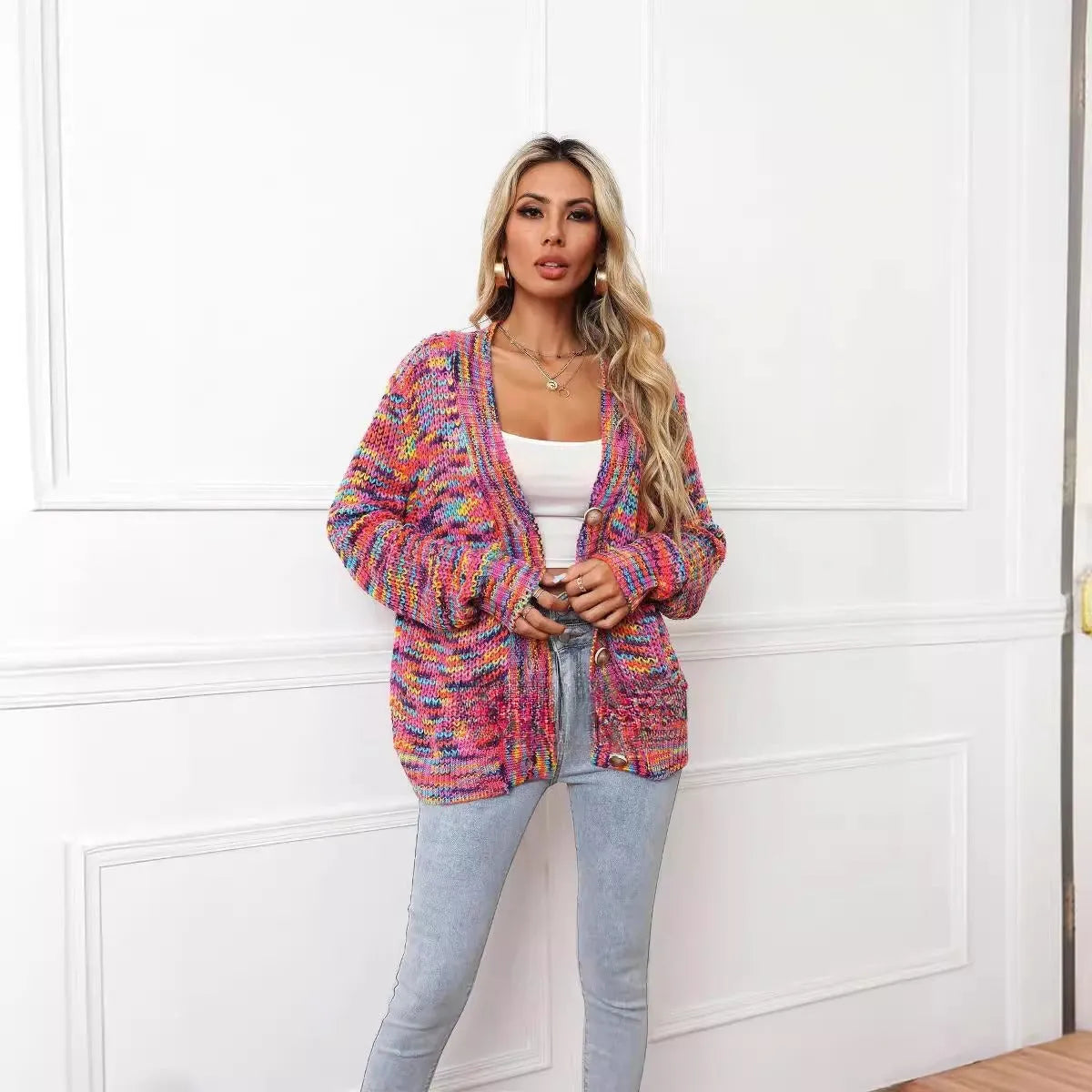 Rose red loose fit knitted cardigan coat with rainbow coloured stripes, shown on a model.