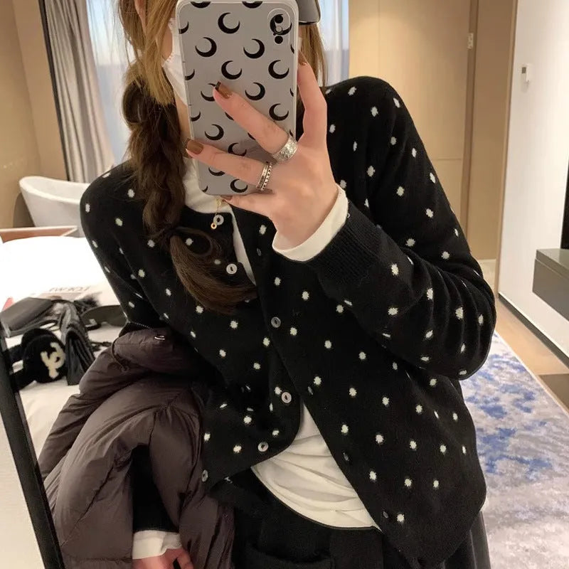 Women's grey dot pattern knitted cardigan with crochet floral detail on the front.