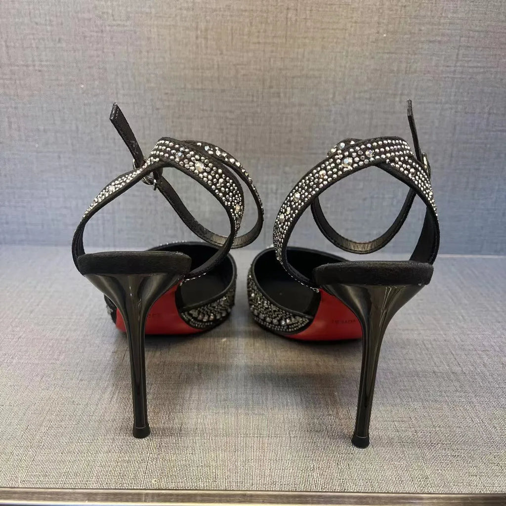Women's black high heels with hollow design, red sole, and pointed toe on stiletto heel
