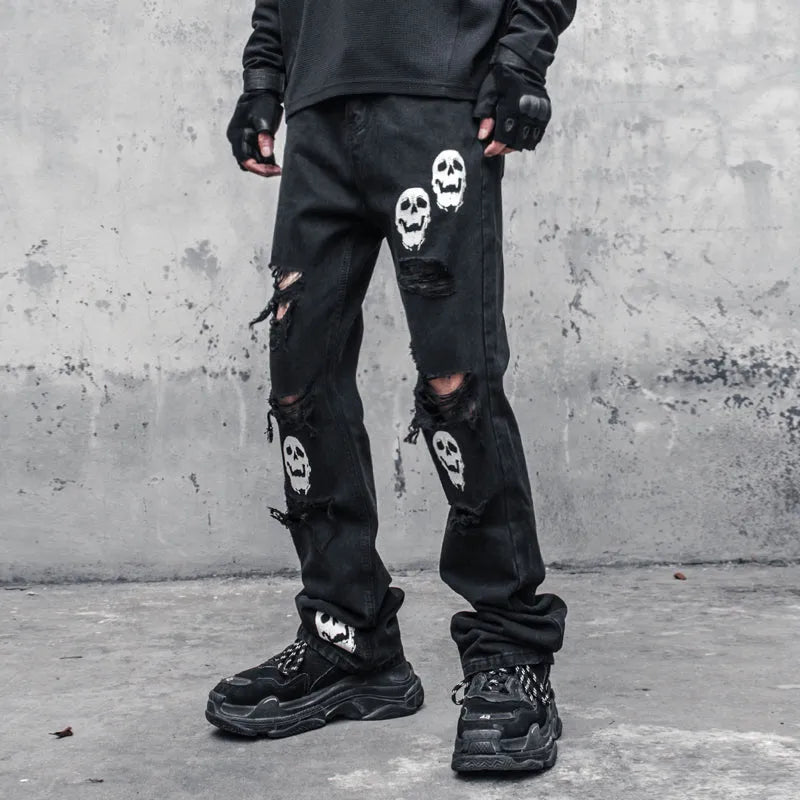 Black cotton denim jeans with skull and crossbones distressed design, mid waist, fit flared horn trousers for men.