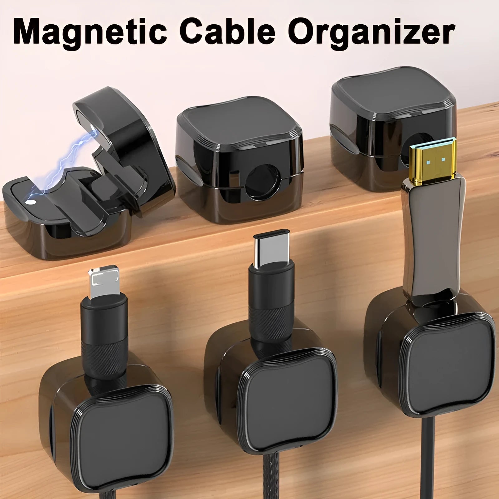 White and black magnetic cable clips holding a USB cable against a wooden desk edge.