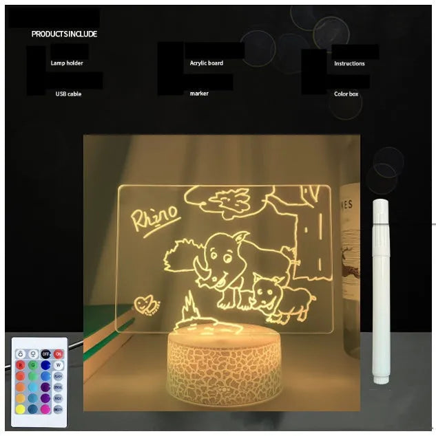 3D acrylic message board night light with remote control and stylus on a desk.