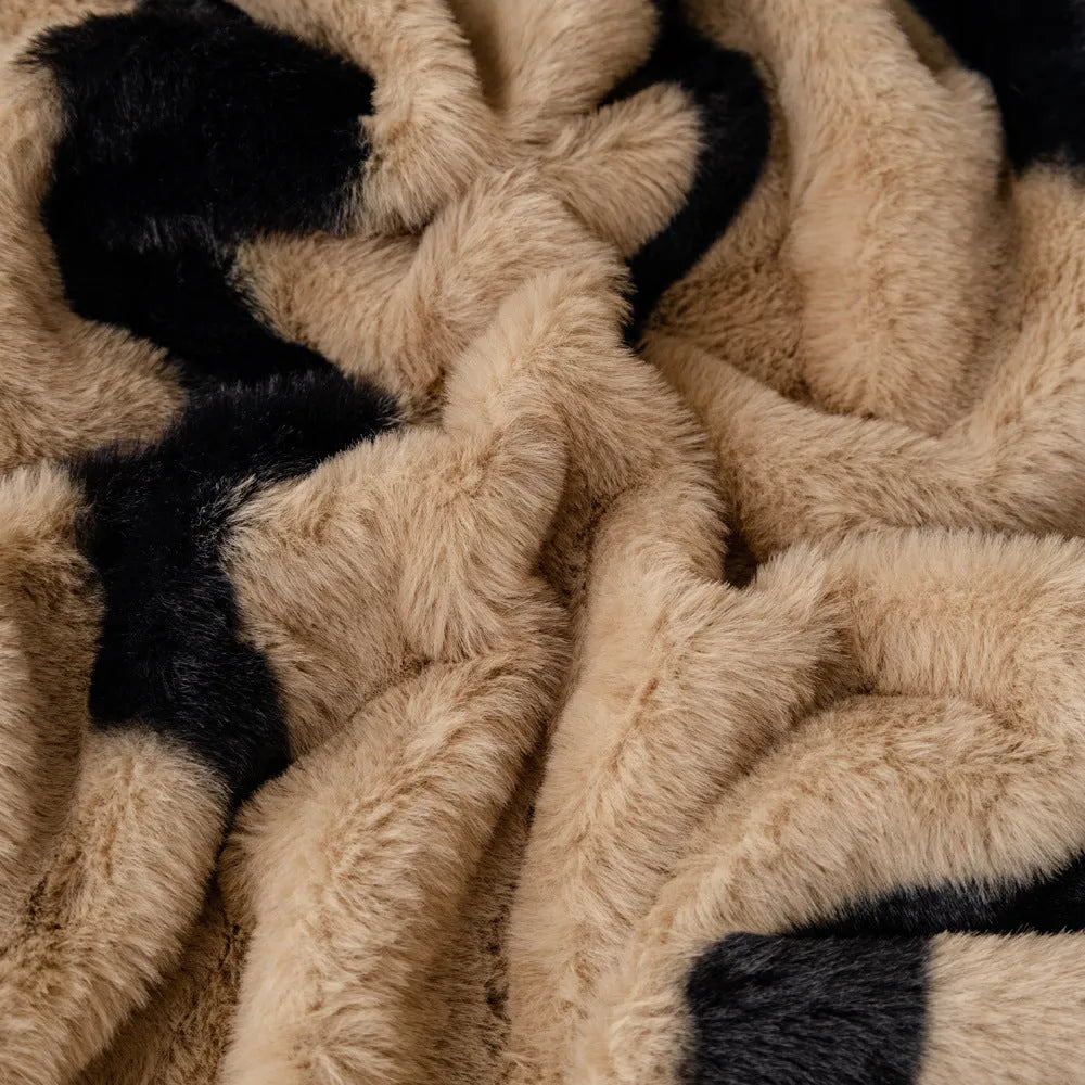Zebra pattern flannel sofa cover draped over a sofa, showing non-slip underside and matching pillowcase.
