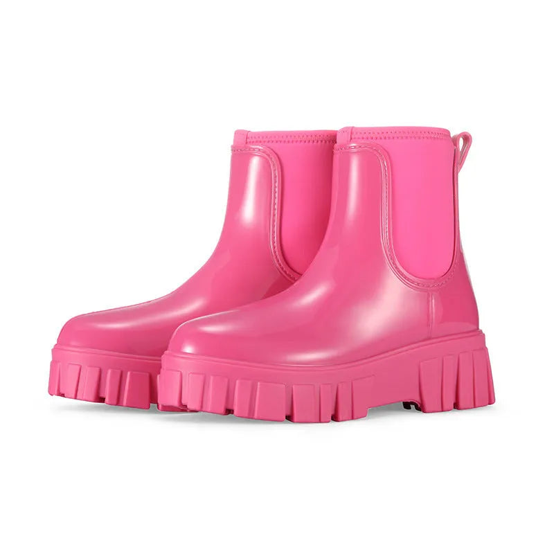Women's creamy-white PVC rain boots with low tube shaft and flat heel on wet surface