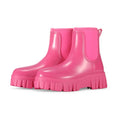 Women's creamy-white PVC rain boots with low tube shaft and flat heel on wet surface