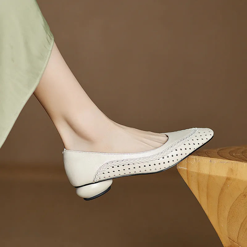 Women's beige mid-heel sandals with hollow-out design and round toe on a light background.