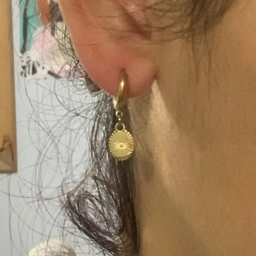 A pair of stainless steel ellipse-shaped stud earrings with butterfly clips on a white background.