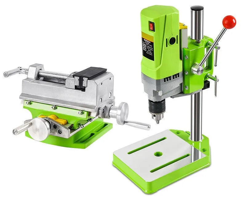 Mini bench drill and milling machine on a workbench with bench pliers.