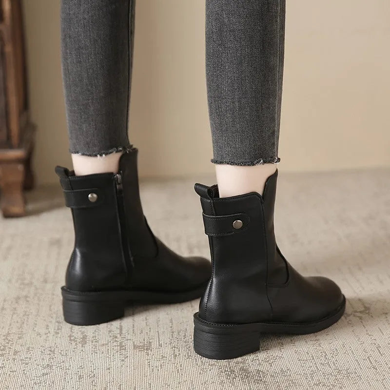 Black women's ankle boots with a side zip, round toe, and a low rubber sole.