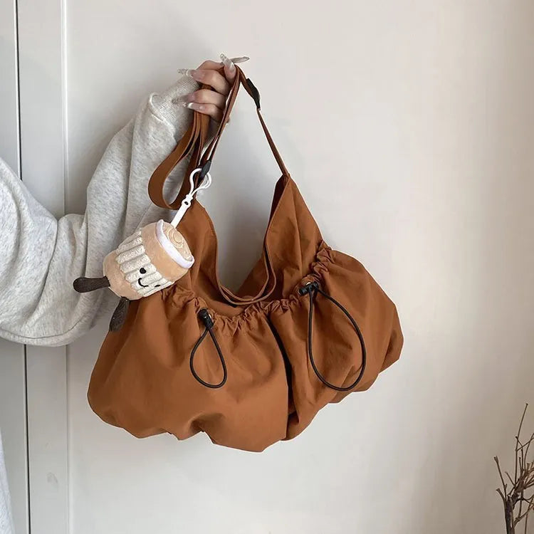 Ultra-light pleated crossbody bag in soft polyester fabric showing split pocket and phone compartment