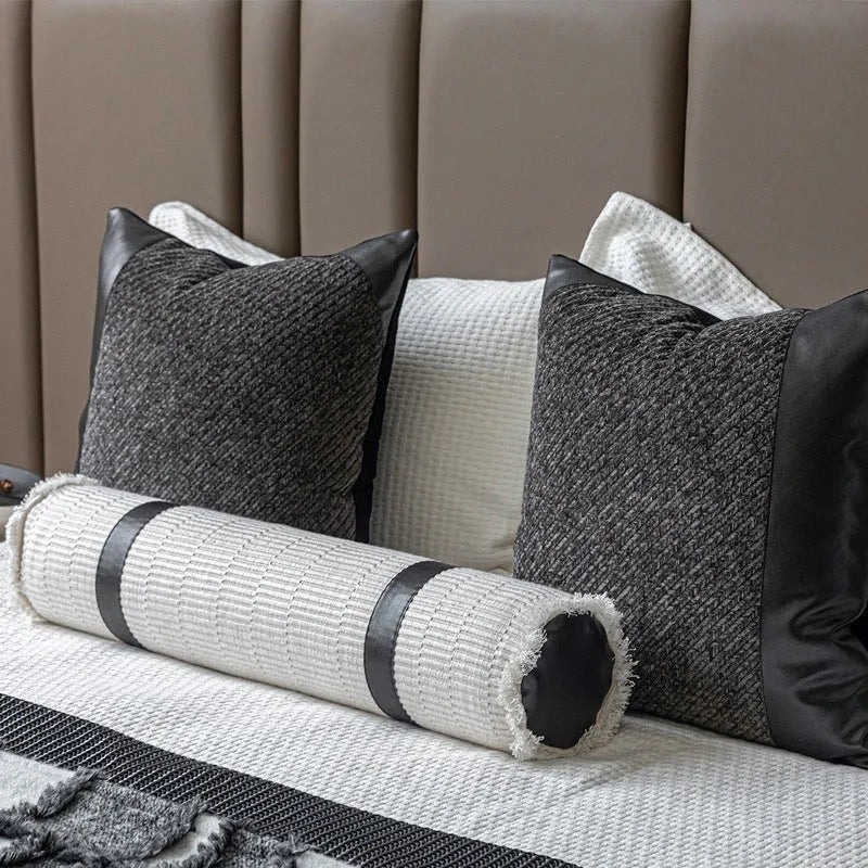 Modern minimalist grey and white plaid bed runner blanket set with a leather round pillow on a bed.