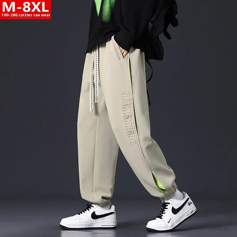 Men's grey green loose-fit cargo trousers with visible stitching detail and a banded ankle opening.