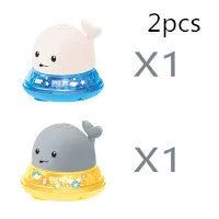 Whale-shaped electric bath toy spraying water with flashing lights, floating in baby bathtub