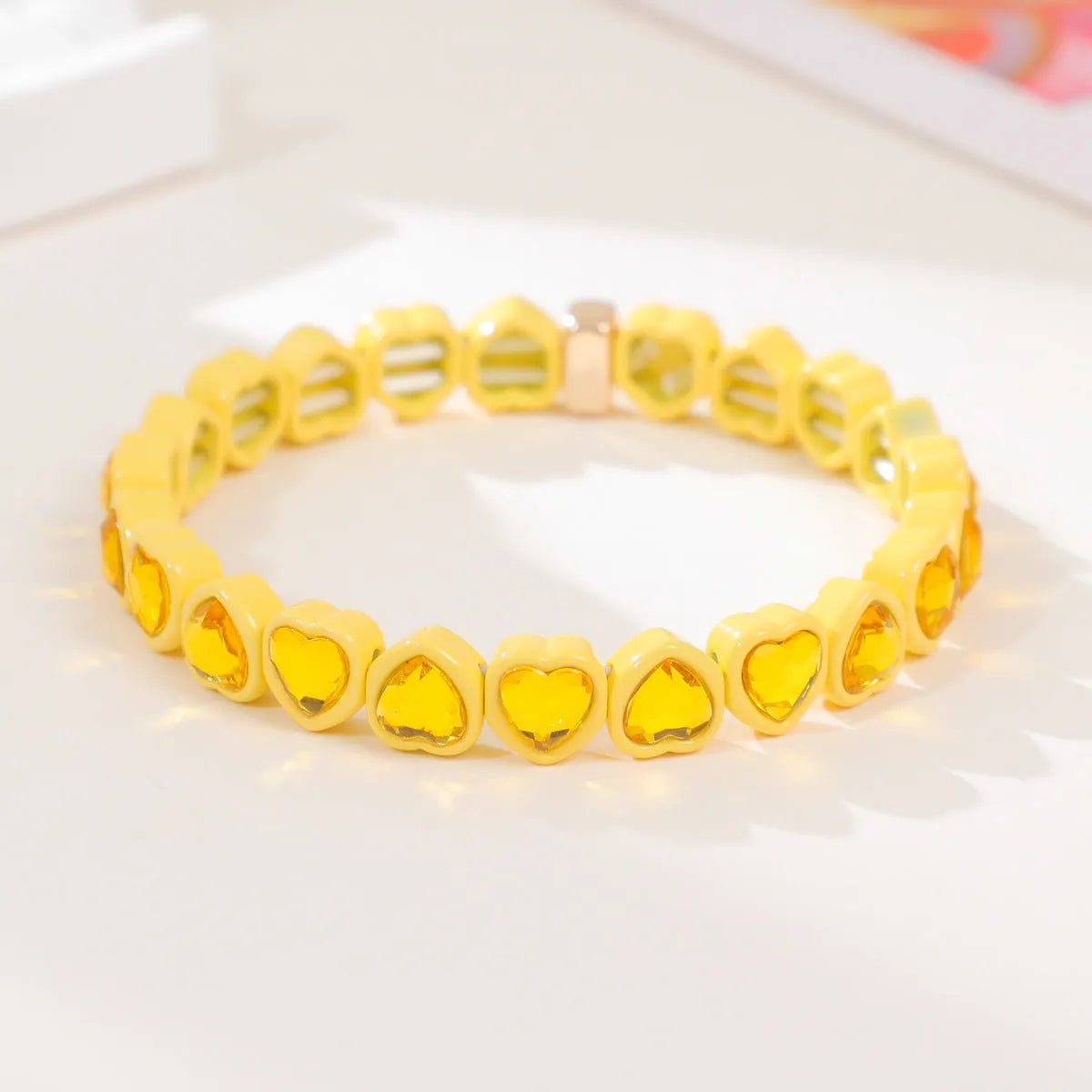 Rainbow coloured alloy heart charms on a stretchy elastic bracelet.