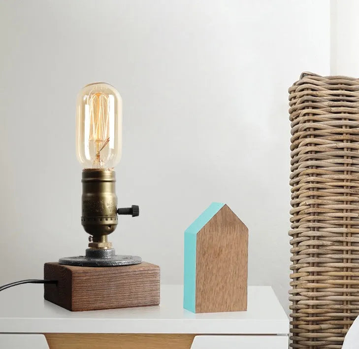 Compact wooden and iron water pipe style table lamp on a surface