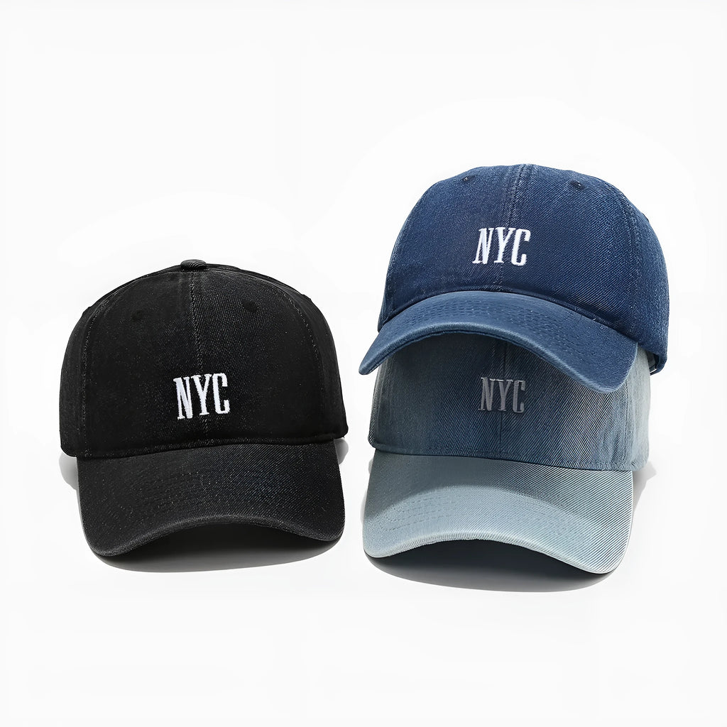 A light blue denim peaked cap with a dome crown, adjustable strap, and decorative white English letters on the front.