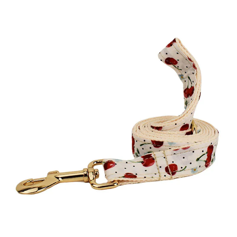 Red cherry print dog collar and leash set with light gold metal buckle and attached cloth bow