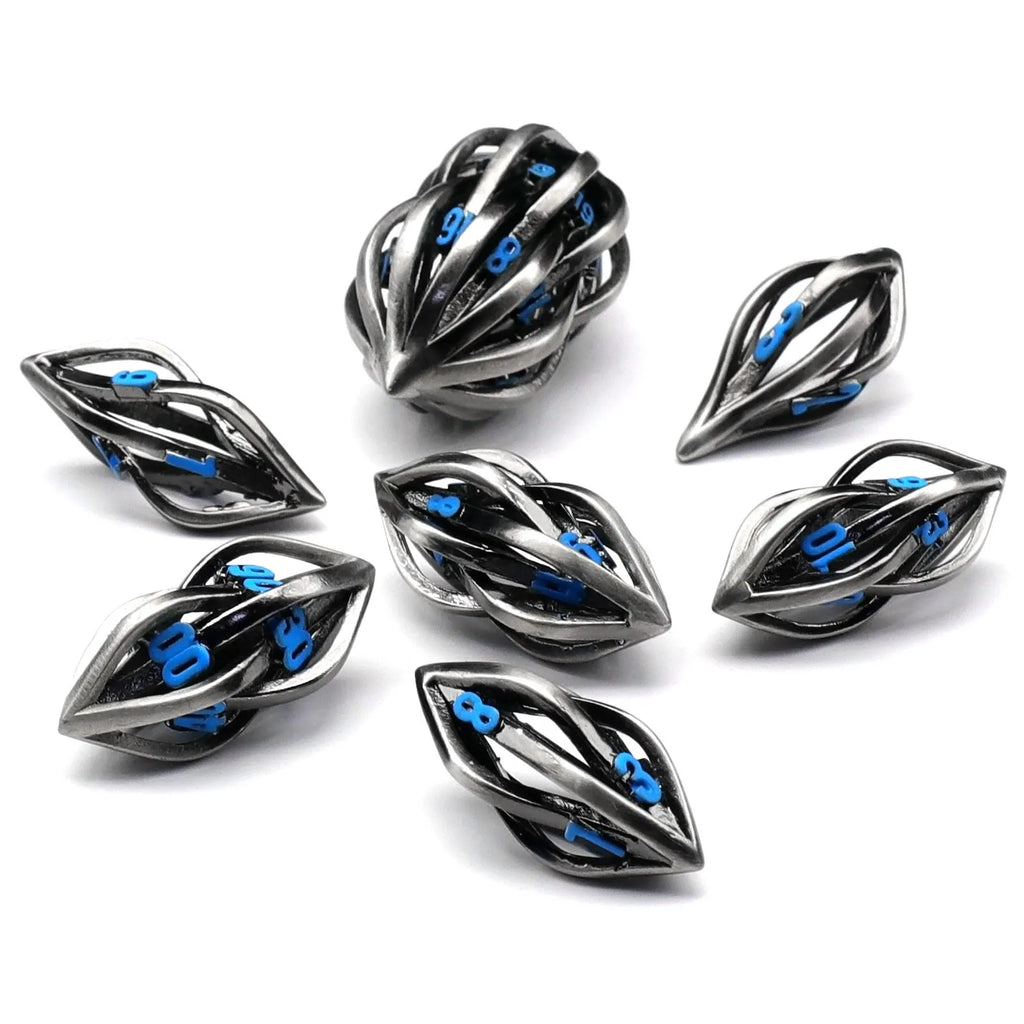 Seven metal melon seed shape dice in antique silver with coloured characters on a surface