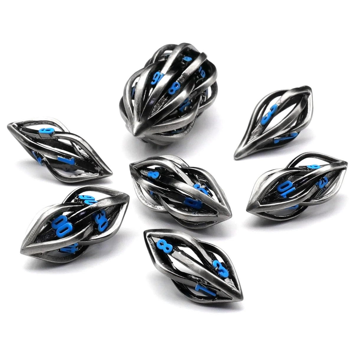 Seven metal melon seed shape dice in antique silver with coloured characters on a surface