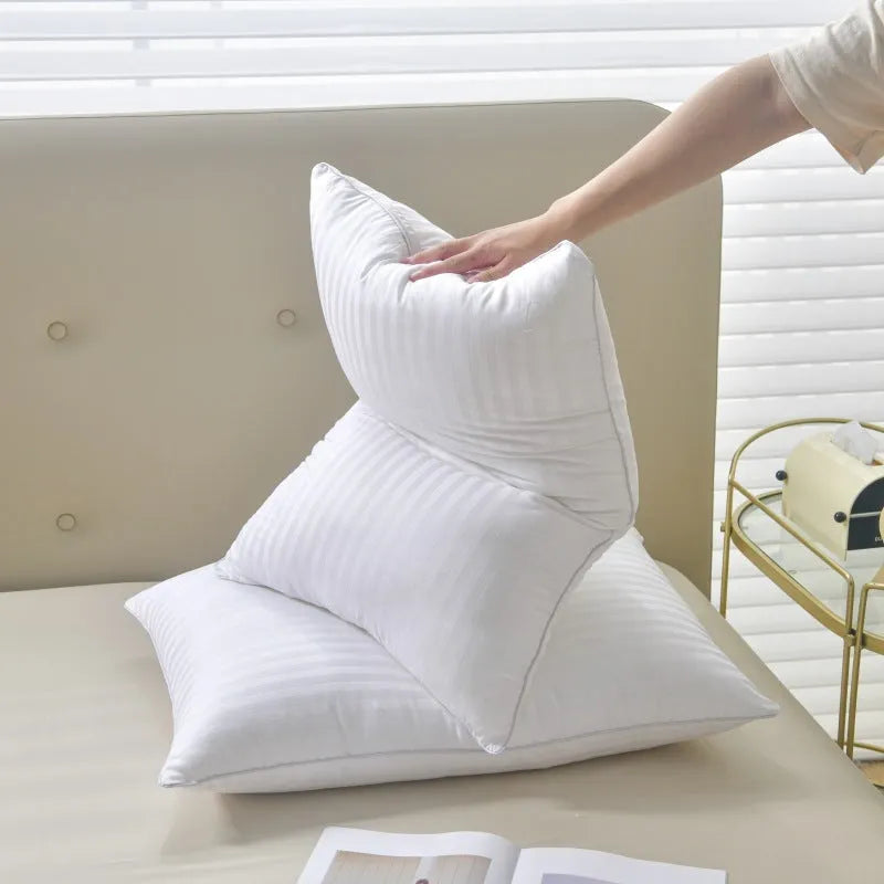 White cotton satin stripe pillow with feather and cotton filling on a bed.