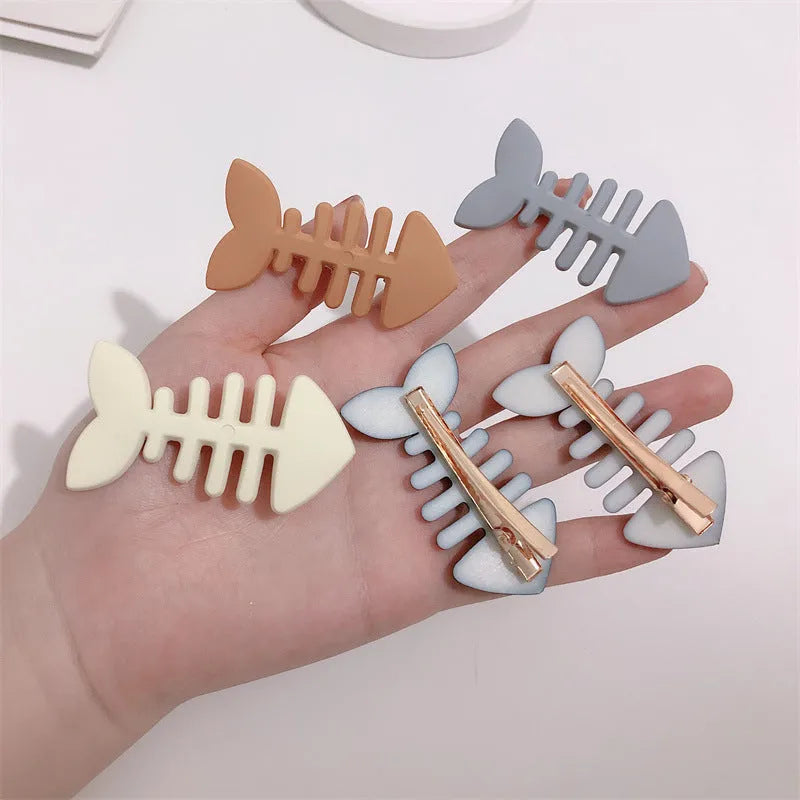 A minimalist fishbone design duckbill clip hair barrette in a muted candy colour.