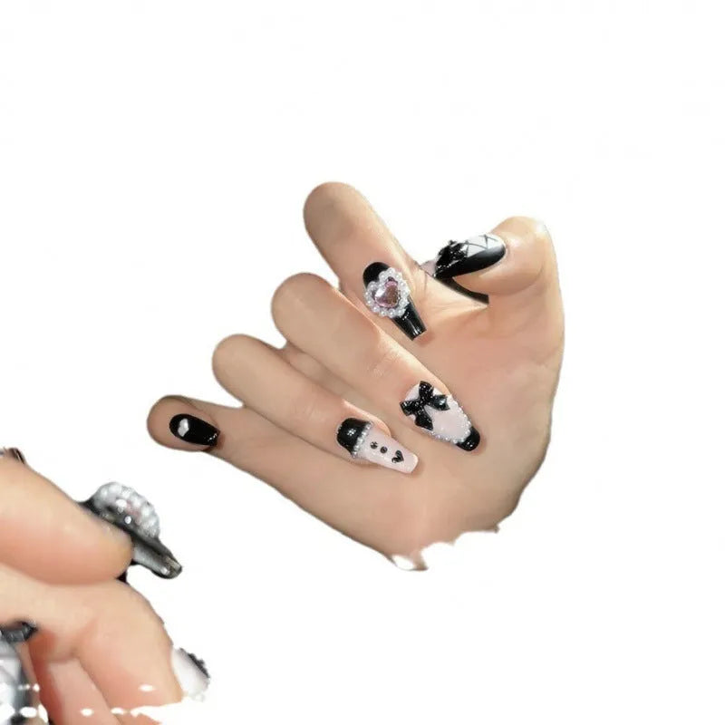 Black and pink heart-shaped hand-painted press-on artificial nails in cat's eye style