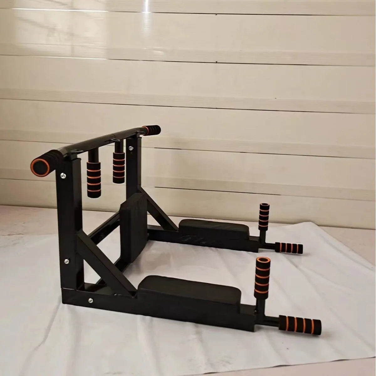 Black wall-mounted steel fitness equipment with parallel bars and sandbag rack attachments for home gym training