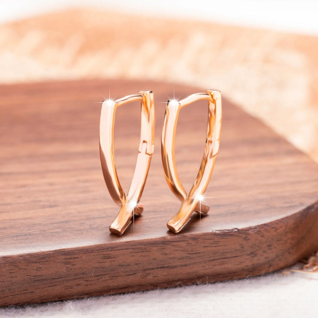 Rose gold cross shaped earrings on a copper base, light luxury style