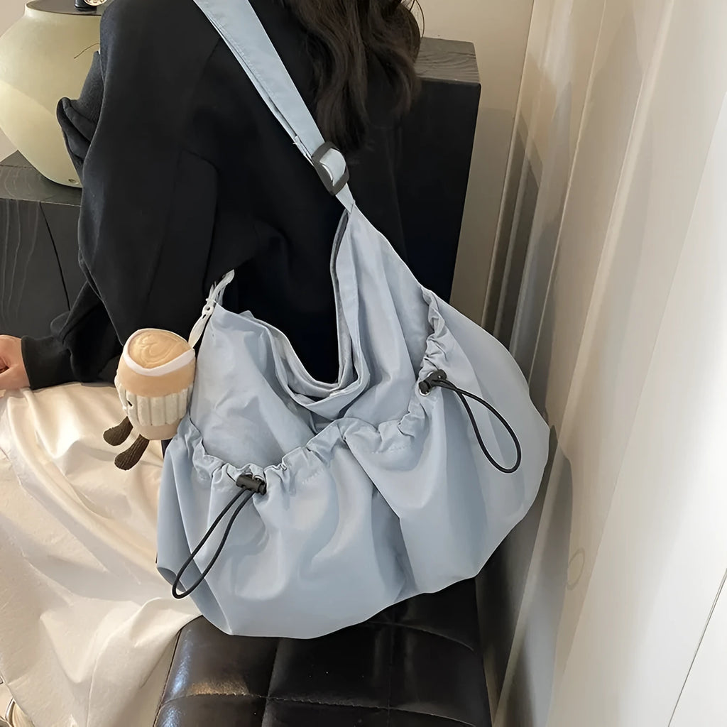 Ultra-light pleated crossbody bag in soft polyester fabric showing split pocket and phone compartment